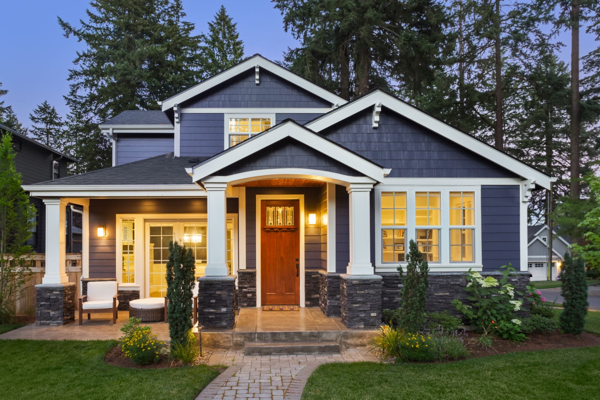 Residential exterior painting of a home with blue siding and white trim.