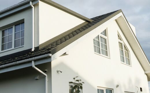 A House Featuring White Exterior And Windows, With Roofing Services Available.