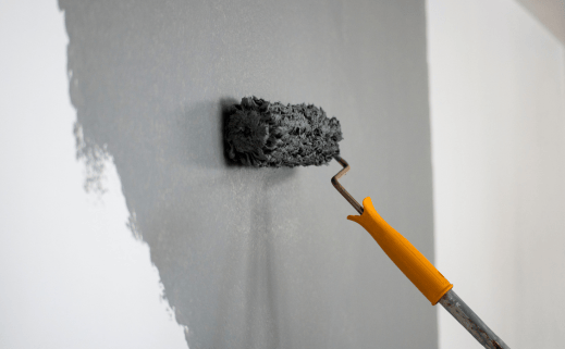 A Person Is Using A Paint Roller For Residential Interior Painting.