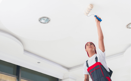 A Man Performing Residential Interior Painting On A Ceiling.